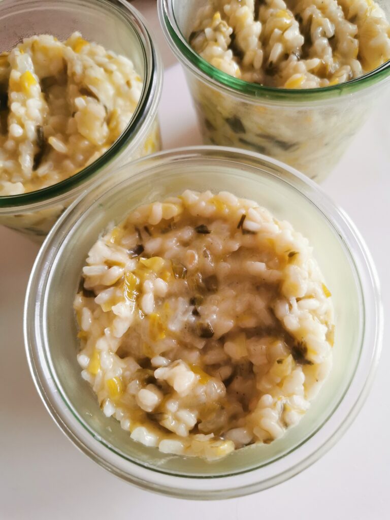 Risotto crémeux aux légumes servi dans des bocaux en verre, une alternative zéro déchet pour un repas végétarien fait maison."